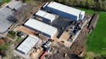 Aerial view of the school site to show how work is progressing with all four buildings in place, with several vehicles operating. 