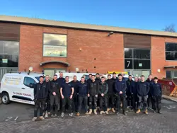 A group photo of staff standing outside the Lukes and Godwin offices 
