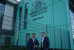 Councillor James Gamble and Councillor Faz Choudhury standing in front Oak House with Nottinghamshire County Council logo in the background
