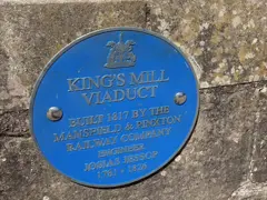 A blue plaque on a stone wall with the words King's Mill Viaduct.