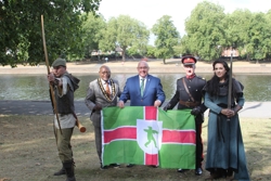 L-R Robin Hood is holding a bow and arrow, poised to shoot. He is standing next to Council Chairman,  the council leader,  Deputy Lieutenant and Lady Marian
