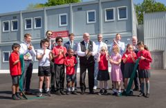 Pupils, teachers and councillors are all clapping after the ribbon has been cut. This is to celebrate the official opening of the learning village.