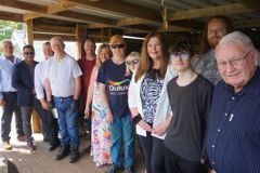 Councillors, volunteers gather in the shed area of the community allotment 