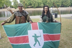 Robin Hood and Maid Marian pictured with the Nottinghamshire flag on the banks of the River Trent.
