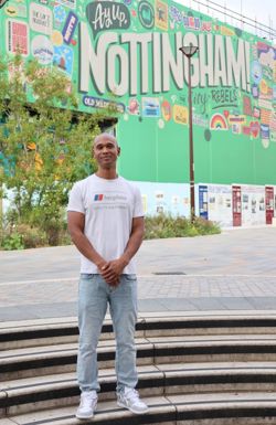 Chris Oliver, local poet, in front of a wall with a Nottingham mural 