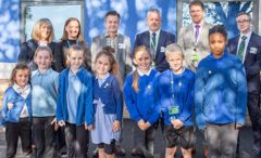 Pupils, councillors and partners are lined up in front of the new classroom block 