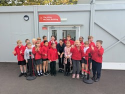 Vicky McClure has just cut a red ribbon to officially open the building - she is surrounded by pupils with everyone smiling and laughing  