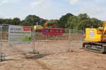 A banner on a fence next to the digger at the Kirk Hill site