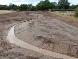 Reshaping of water course upstream of East Markham. Meandering water channel with banks of soil either side.