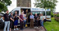 Volunteers, staff and members of the community are standing around the new minibus