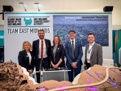 This shows a line up of local representatives, including from the county Council, standing in front of a sign which says Team East Midlands