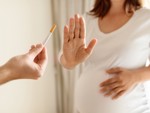 A pregnant woman saying no to being offered a cigarette 